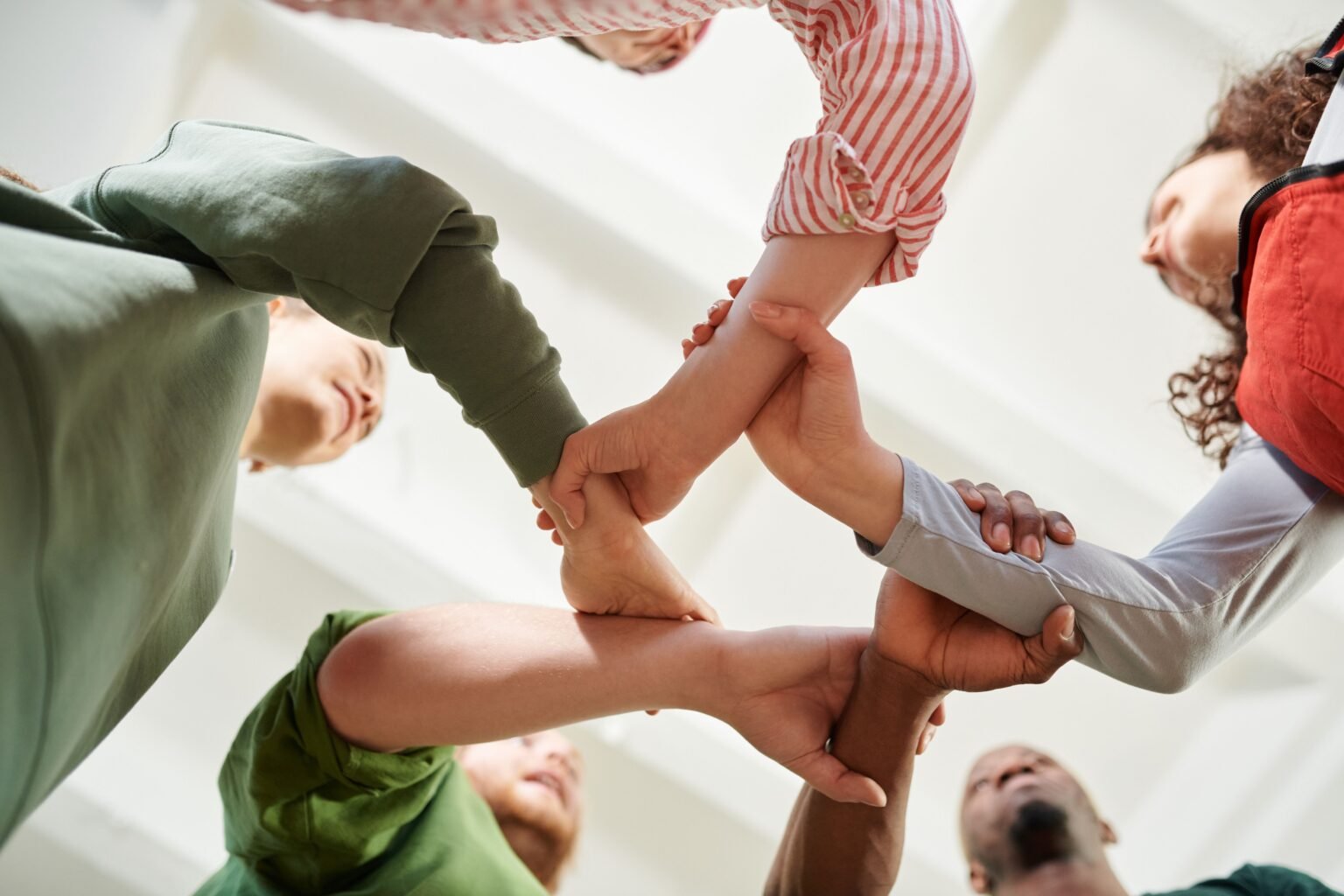 Hands joined together in a circle, representing community and belonging