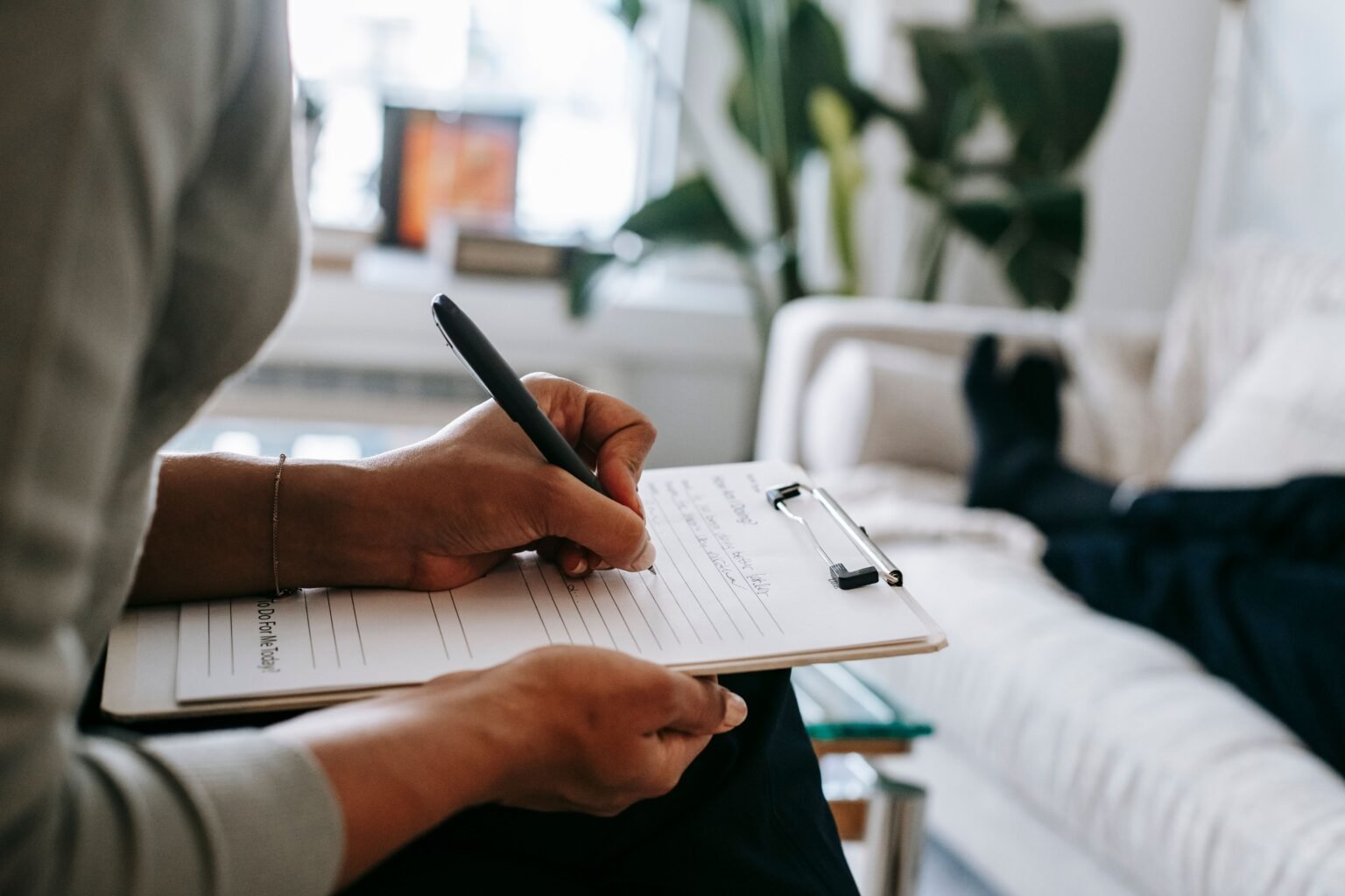 Therapist completing an assessment form on a clipboard